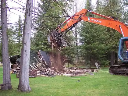 Wood-frame barn teardown, timbers and roofing in the pile