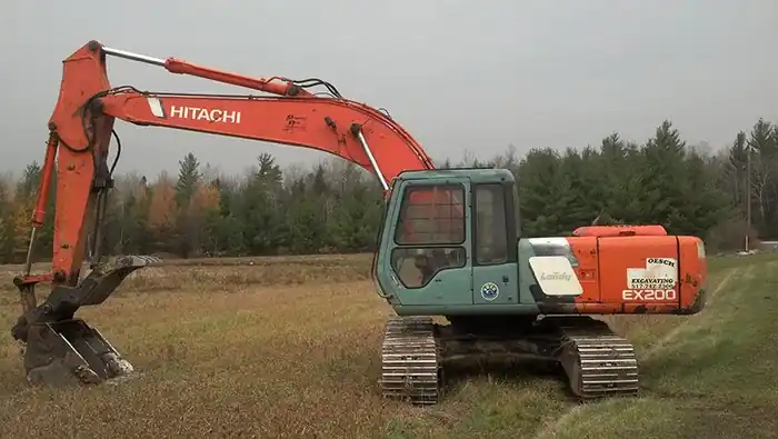 Orange Hitachi excavator parked on a cleared field