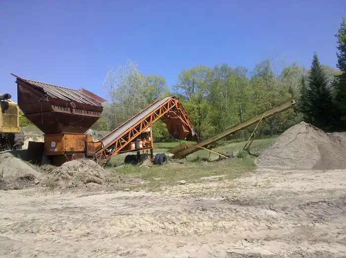 Topsoil screening plant beside a pile of screened soil